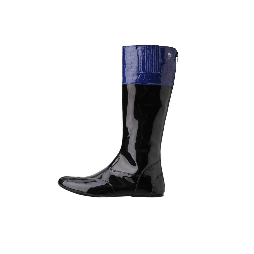 A tall racing boot against a white background. The boot is made out of black material with blue crocodile accents around the calf area. It features a back zip and a 1.5-2cm stretch feature around the calf. The boot is crafted from light, tough, flexible, and strong material.  This image showcases only one boot from a side perspective.