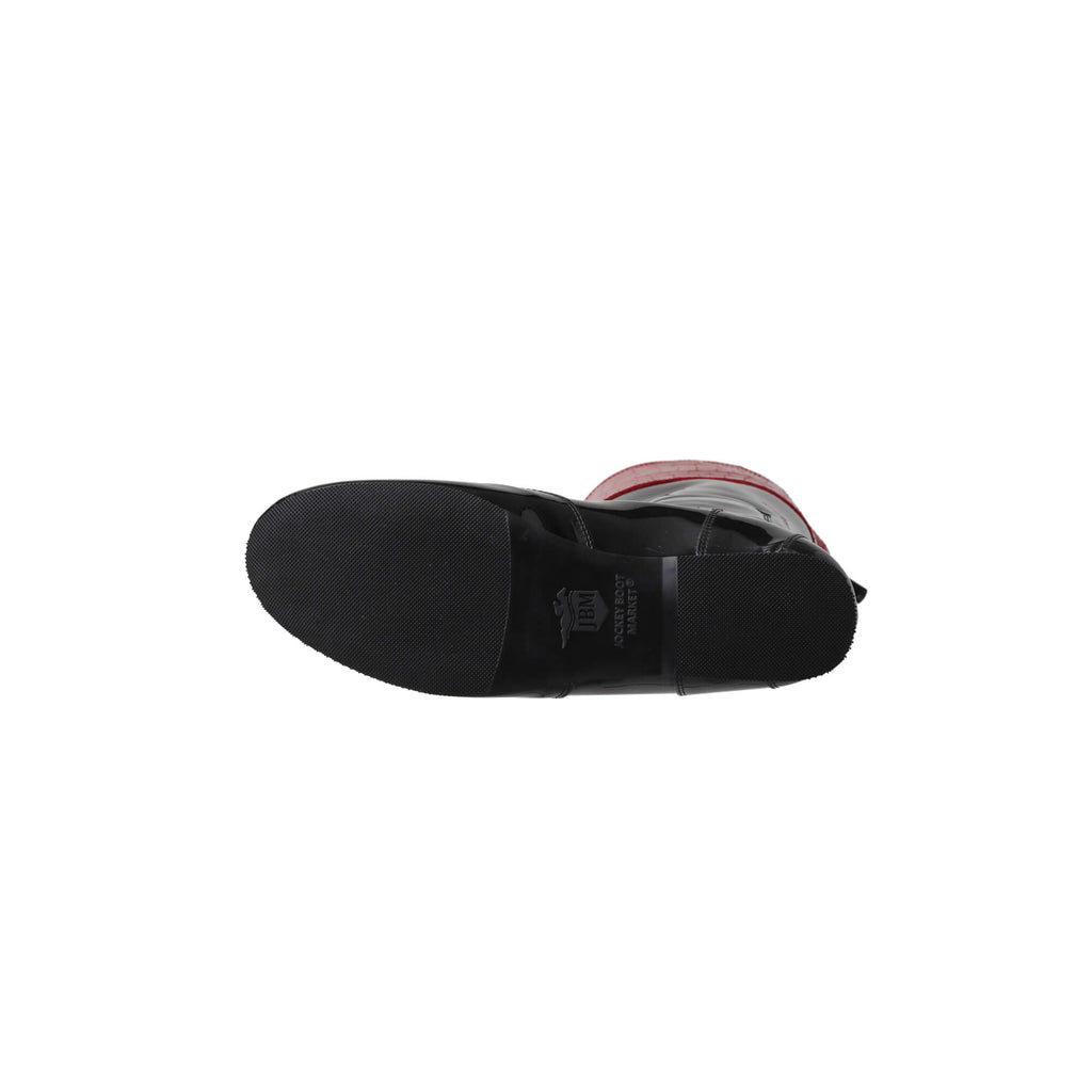 A tall racing boot against a white background. The boot is made of black material with red crocodile accents around the calf. It features a back zip and a 1.5-2cm stretch feature around the calf. This image displays a single boot laid down to showcase the sole.