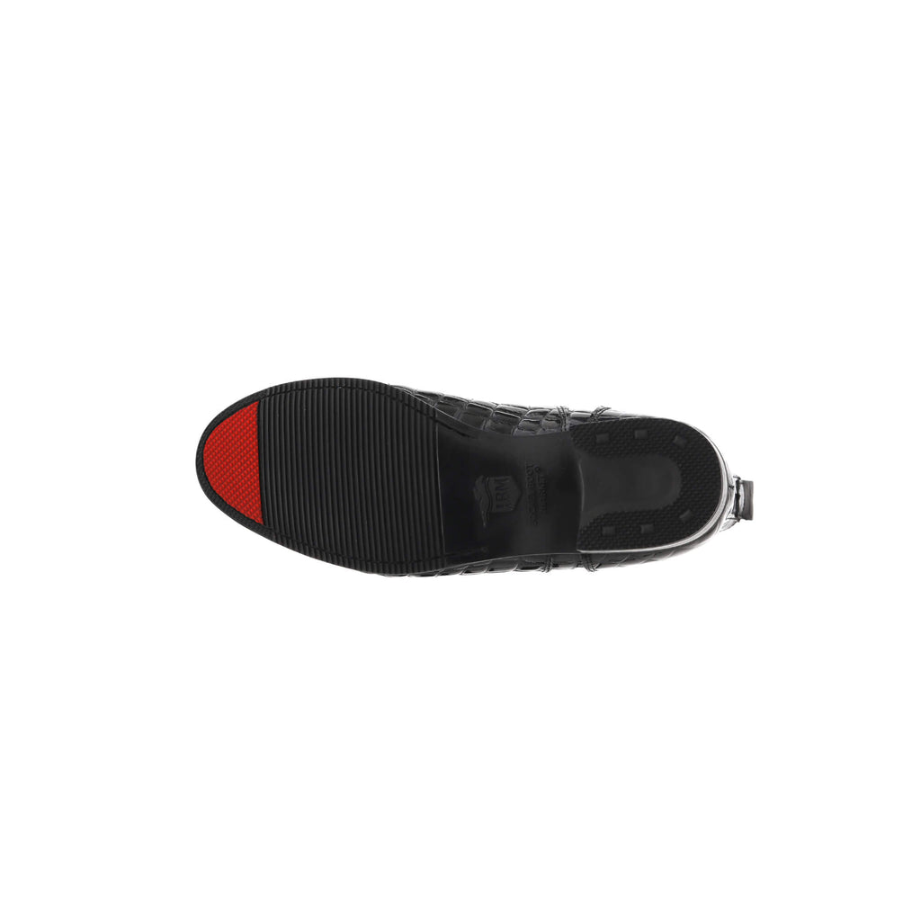 A single black crocodile short boot laid down to display the sole, featuring a front zip with a buckle, against a white background. The sole has a red tip, characteristic of the boot's signature design.